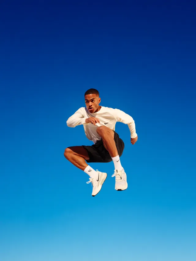 Energetic Runner Mid-Jump Against Blue Sky