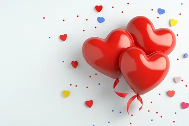 3D red hearts and polka-dot ribbons on a bright white background with confetti accents, flat lay.   bfjamcp --s 250