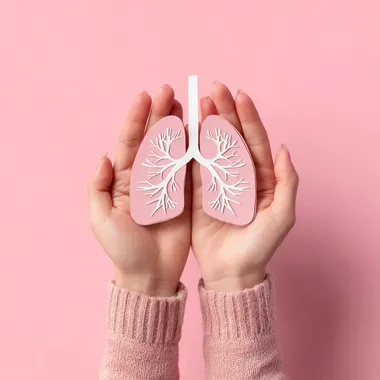 Female hands holding paper lungs on pink background. Lung cancer concept