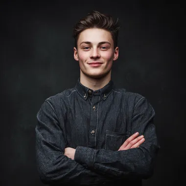 happy young man looking at front wearing shirt with hands crossed and solid black as the background