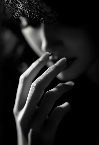 A close-up of the woman's hand, holding her cigarette between two fingers with light illuminating it from behind, creating an atmosphere of mystery and intrigue. The background is blurred to focus on the details of her hands, adding depth and texture to the overall composition. The black and white photography style adds contrast and intensity, highlighting the dramatic effect of the lighting. The woman is wearing .