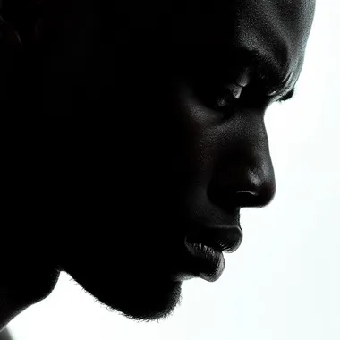 Half silhouette face of an african man, face down, depressed, close up shot, white background