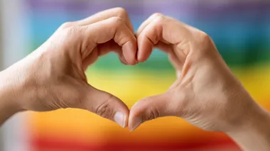 Hands making heart sign in front of rainbow flag, high-resolution, ultra-high quality Depth & Sharpness, no logos, bright lighting, soft shadows, perfect for stock photo.  --raw rofile d3xh2hv