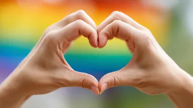 Hands making heart sign in front of rainbow flag, high-resolution, ultra-high quality Depth & Sharpness, no logos, bright lighting, soft shadows, perfect for stock photo.  --raw rofile d3xh2hv