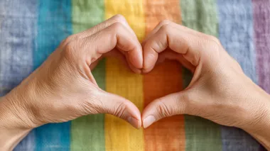 Hands making heart sign in front of rainbow flag, high-resolution, ultra-high quality Depth & Sharpness, no logos, bright lighting, soft shadows, perfect for stock photo.  --raw rofile d3xh2hv