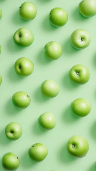 a top view photo of green apples on solid light green background