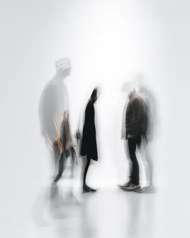 Blurred human figures in motion, against a white background with minimalist text, creating an abstract and artistic composition. The blurred images of the people create depth and movement within the scene while also serving as visual elements for design or graphic work. The overall effect is one that captures both contemporary aesthetics and emotional essence through its simplicity and minimalistic approach.