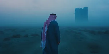 saudi king, back shot, standing in a windy desert, blue hour, futristc buildings of Ditaiyah raising from the ground