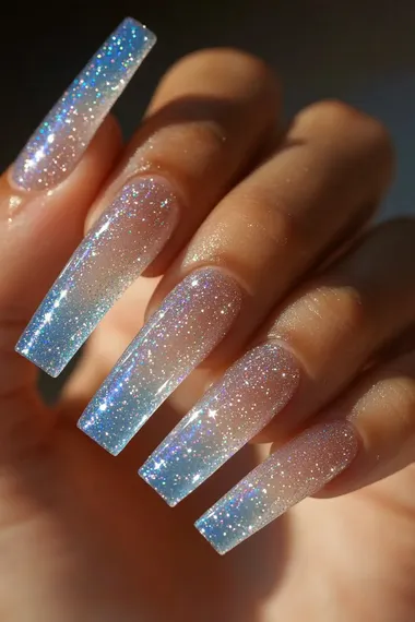A photo of a woman's hand with long coffin nails with sparkly textured glitter of blue and white candy cane stripes