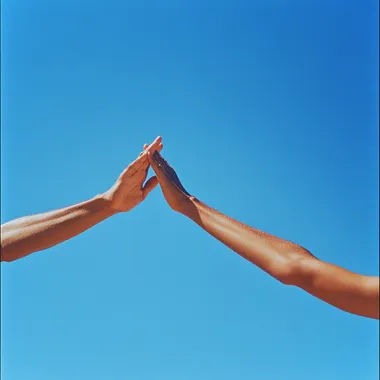 a Peaceful photo taken with kodachrome and a 28mm lens two arms of a person with latin skin streched up to the blue sky and crossing against each other with a blue sky on the back