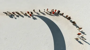 Top view of tiny people forming cirle groups, converging toward a center point, minimalist white background, aerial drone photography style, soft shadows, precise symmetrical composition, ultra-realistic texture, Sony A7R IV and 85mm f/1.4 lens