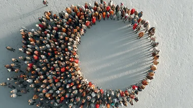 Top view of tiny people forming cirle groups, converging toward a center point, minimalist white background, aerial drone photography style, soft shadows, precise symmetrical composition, ultra-realistic texture, Sony A7R IV and 85mm f/1.4 lens