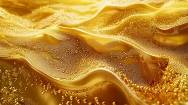 Create a realistic image of a vibrant golden texture resembling a glittering surface, with a rich, warm yellow color scheme. The image should convey a sense of warmth and richness, showcasing the shine and sparkle typical of a gold material.