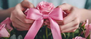 Delicate hands tying a pink ribbon around a bouquet of pink roses, symbolizing love and appreciation, cinematic close-up.,    773tzfv