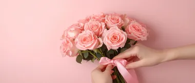 Delicate hands tying a pink ribbon around a bouquet of pink roses, symbolizing love and appreciation, cinematic close-up.,    773tzfv