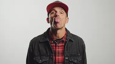 portrait photography of a standing, smart, cool, 40- year old skater guy sticking his tongue out, in modern clothes in front of a white background. from the waist up, Terry richards style