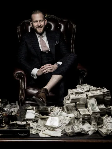 spotlight on a white businessman in suit sitting with shoes up on desk smiling, his desk is full on piles of cash, black background   rofile ncdd2gx   --raw