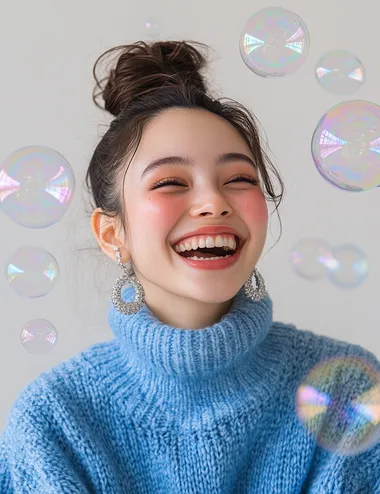 A photo of a happy woman with her hair in a bun, wearing silver earrings and a blue sweater against a white background with soap bubbles around her head, in the style of Clothesam Lau, with a laughing expression.