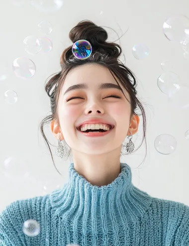 A photo of a happy woman with her hair in a bun, wearing silver earrings and a blue sweater against a white background with soap bubbles around her head, in the style of Clothesam Lau, with a laughing expression.