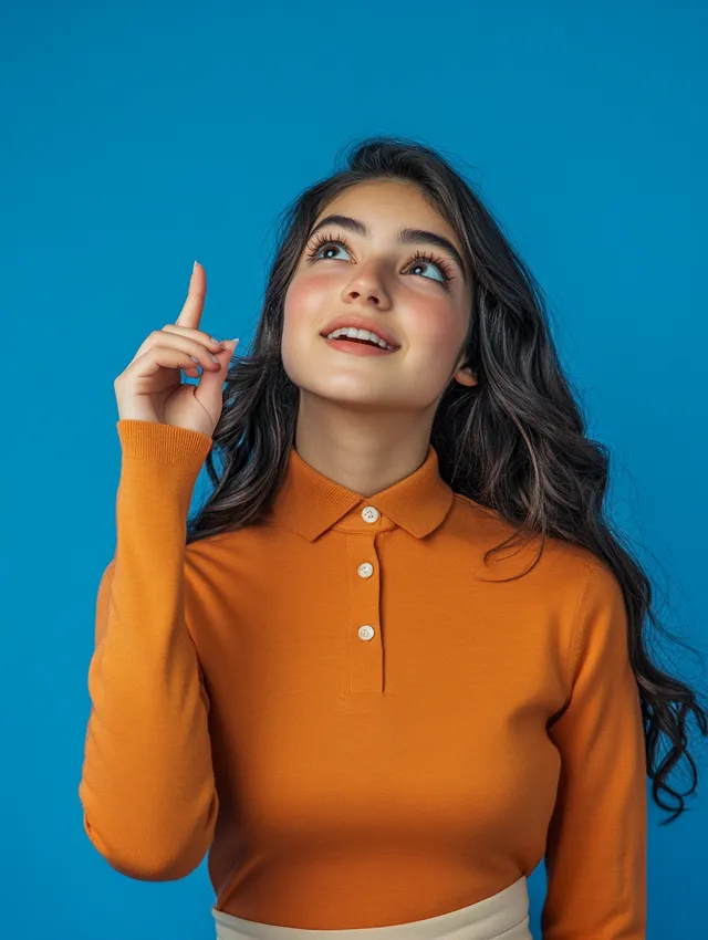 a woman in an orange shirt pointing to the sky