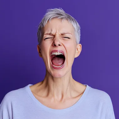 yelling mature woman with short hair on a periwinkle background