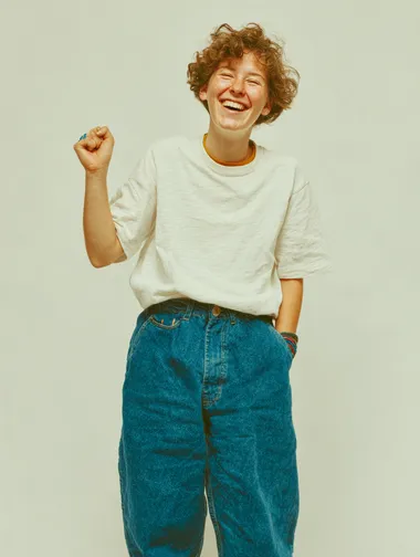 young happy woman with one hand up, wears jeans and a white t.shirt. isolated white background. full body shot  rofile b4lvlaf
