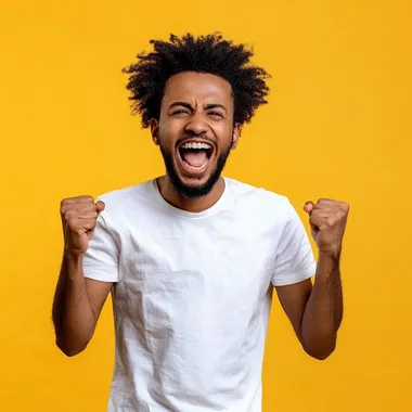 Cheerful ethiopian man with afro dressed casual clothes celebrate success raise hands fists isolated on golden color background. he is between 20 to 30 years old. he is good looking . he is screaming with his mouth slightly open . he have dark skin . he have ethiopian skin tone