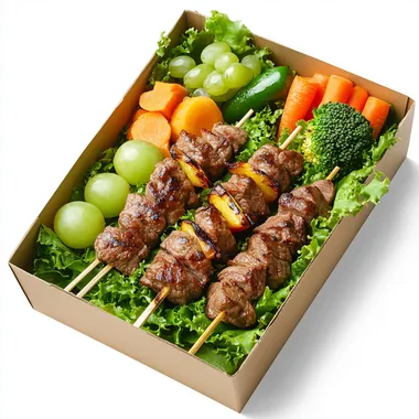 The food box has lettuce base, 3 beef skewers and vegetables on top, along with some boiled broccoli, boiled carrots, and 1 small bunch of green grapes. Place inside a paper box. The most realistic image