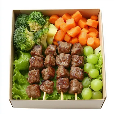 The food box has lettuce base, 3 beef skewers and vegetables on top, along with some boiled broccoli, boiled carrots, and 1 small bunch of green grapes. Place inside a paper box. The most realistic image
