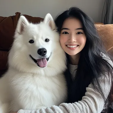 a picture of a samoyed dog and its owner sitting on a couch, looking at the camera and smiling