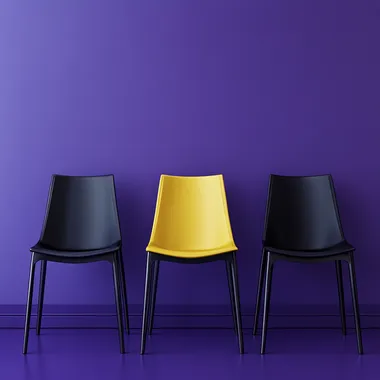 A hyper-realistic, high-resolution photograph of five chairs neatly aligned side by side in a modern interior setting. Four of the chairs are dark-colored (black or deep plum), and the center chair is bright yellow, placed precisely in the middle to draw focus. The scene is set against a smooth matte purple wall and a matching purple floor, creating a soft monochromatic atmosphere. The lighting is natural softbox-style, coming slightly from the side and above, subtly highlighting the texture and color of the yellow chair to make it stand out. Include soft shadows, reflections on the floor, and slight depth of field (bokeh effect) to mimic a shot taken with a DSLR camera using a 50mm f/1.8 lens. The overall image should feel sharp, clean, and cinematic, with balanced contrast and realistic material textures like fabric and plastic or metal on the chairs.