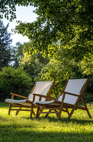 Two wooden garden chairs with white fabric on the lawn in front of trees, shot from a distance, on a sunny day, using a Nikon Z7 II and natural light.