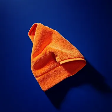 small orange washcloth floating against solid dark royal blue background