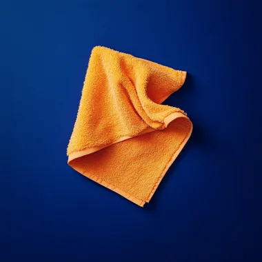 small orange washcloth floating against solid dark royal blue background