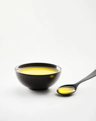 front view of a bowl cream and a spoonful of olive oil in the foreground, on a white background. Realistic photo, high resolution