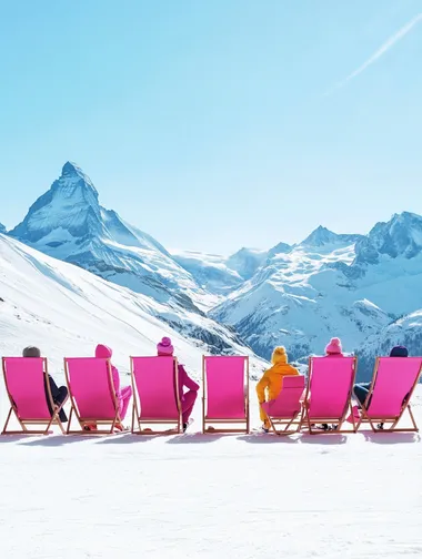Five foldable deck chairs in a bright pink color, arranged in a neat row on a pristine snowy surface. Each chair is occupied by stylish women dressed in chic, vibrant ski suits, creating a lively and fashionable atmosphere. The chairs feature sleek designs with matching pink fabric. In the background, towering, snow-covered mountains rise against a clear blue sky, while the sunlight casts a soft glow, illuminating the snow and adding a warm, inviting feel to the scene --s 50