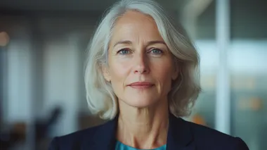 A professional portrait of a confident middle-aged businesswoman, elegantly dressed in a tailored blazer and silk blouse, featuring a custom color palette of warm coral-orange (#F98A71), deep purple (#9265C4), soft cream (#F2ECCE), and vibrant turquoise-green (#6BF2C1). Her poised and determined expression conveys leadership and wisdom. Her short, well-styled hair frames her face, and subtle makeup enhances her natural features. The softly blurred background showcases a modern office with large windows, reflecting hues of the custom color scheme. Cinematic and high-end corporate feel, shot with a Canon EOS R5, 85mm f/1.2 lens, shallow depth of field, natural and balanced lighting, photorealistic textures   rofile d7sot8n