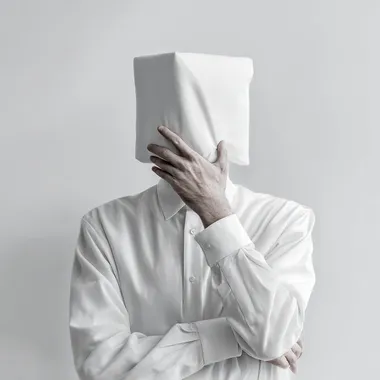 homme blanc fond blanc qui se pose une questionla main sur le monton