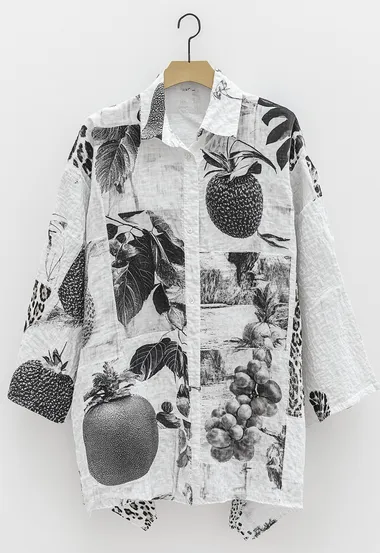 A white women's shirt hanging on the wall, with small areas of leopard print and fruit patterns printed on it, with irregular composition.  4249887665   --s 250