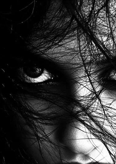 closeup photo. black and white mysterious silhouette of a woman. We can see there is someone but not clearly see who. very dark. we can't see any facial traits