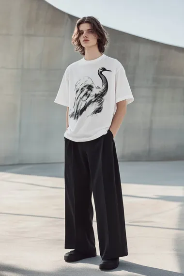 A male model wearing a white T-shirt with a printed swan cloud graphic, black wide-leg pants, in the style of Balenciaga, with a minimalistic design and a monochromatic color scheme. High-resolution photography.