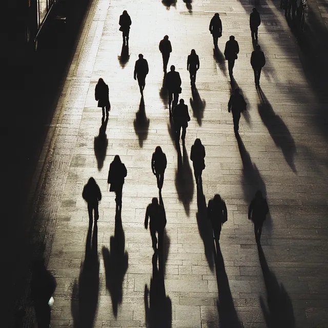 People Walking at Night in Urban Area Casting Shadows on Street