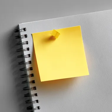 a piece of sticky note paper stuck to a page, top view