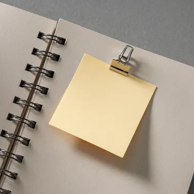 a piece of sticky note paper stuck to a page, top view